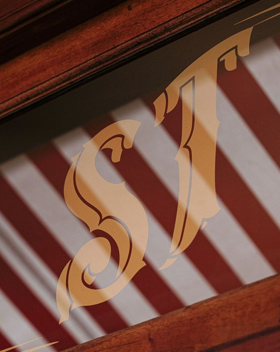 San Telmo's gold ST monogram on a red-and-white striped surface